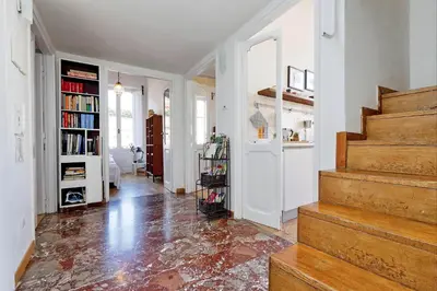a hallway with a staircase in a home with a book shelf at Spagna Penthouse in Rome