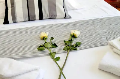 two white roses on a bed with towels at Spagna Penthouse in Rome