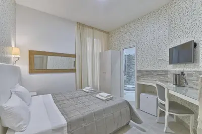 a bedroom with a bed and a desk and a television at Vatican Tourist Inn in Rome