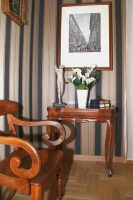 a table with a vase of flowers and a picture at Landlord in Trastevere in Rome