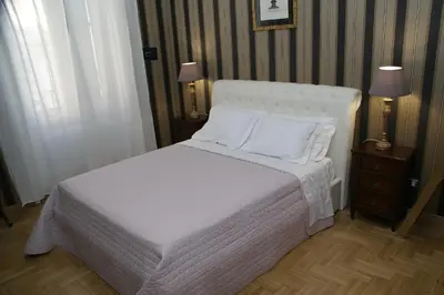 a bedroom with a bed with white sheets and pillows at Landlord in Trastevere in Rome