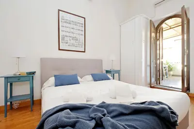 a bedroom with a large white bed with blue pillows at Amleto Apartments in Rome