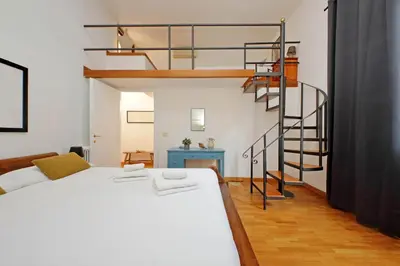 a bedroom with a bed and a spiral staircase at Amleto Apartments in Rome