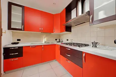 a kitchen with red cabinets and a sink at Amleto Apartments in Rome