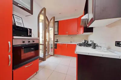 a kitchen with red cabinets and a sink at Amleto Apartments in Rome