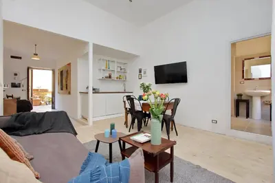 a living room with a couch and a table with flowers at Amleto Apartments in Rome