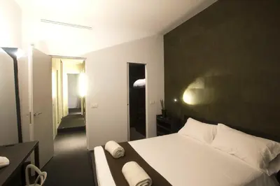 a bedroom with a white bed and a black wall at Vatican Modern Apartment in Rome