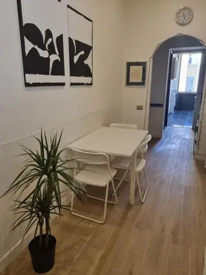 a table and chairs in a room with a plant at B&B Vaticanrooms in Rome