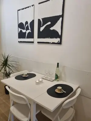 a white table with two glasses and a bottle of wine at B&B Vaticanrooms in Rome