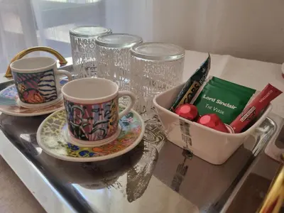 a table with two cups and a bowl of candy at B&B Vaticanrooms in Rome