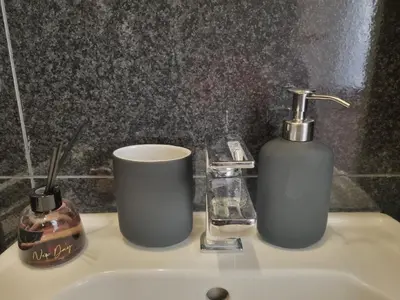 a bathroom sink with two bottles and a soap dispenser at B&B Vaticanrooms in Rome