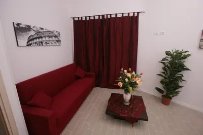 a living room with a red couch and a red curtain at Rooms Monteverde in Rome