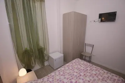a small bedroom with a bed and a chair at Rooms Monteverde in Rome