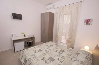 a bedroom with a bed and a desk and a window at Rooms Monteverde in Rome
