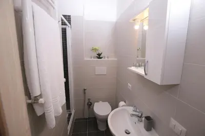 a white bathroom with a toilet and a sink at Rooms Monteverde in Rome