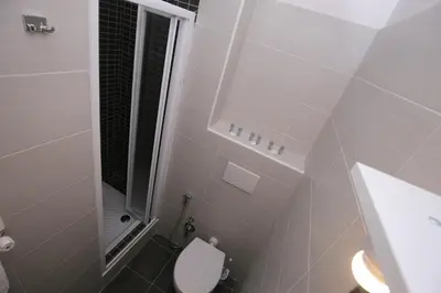 a white bathroom with a toilet and a shower at Rooms Monteverde in Rome