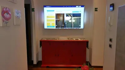 a red cabinet with a large screen on the wall at La Casa Del Pigneto in Rome