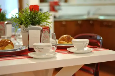 a table with two cups and plates of pastries on it at La Casa Del Pigneto in Rome
