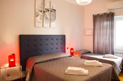 a bedroom with two beds and two red candles at La Casa Del Pigneto in Rome
