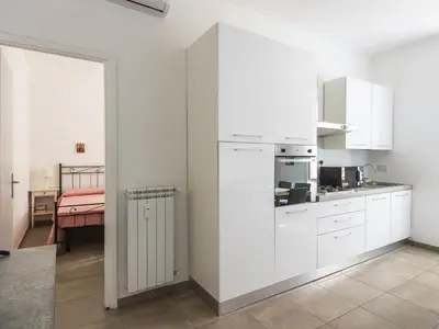 a kitchen with white cabinets and a table in a room at Apartment Il Piccolo by Interhome in Rome