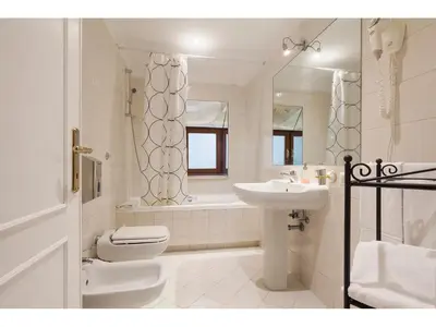 a white bathroom with a sink and a toilet at Apartment Via Giulia in Rome