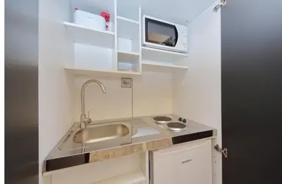 a small kitchen with a sink and a microwave at 4BNB - Domus Colosseo in Rome
