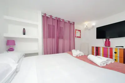 a bedroom with a white bed and a tv at 4BNB - Domus Colosseo in Rome