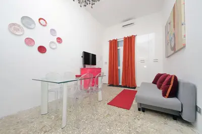 a living room with a glass table and a chair at 4BNB - Domus Colosseo in Rome