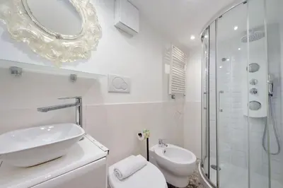 a white bathroom with a sink and a shower at 4BNB - Domus Colosseo in Rome