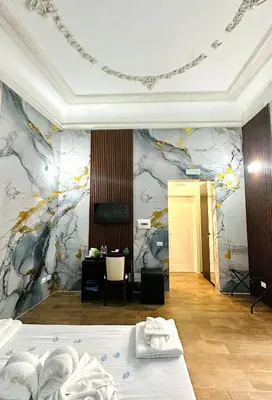 a hotel room with two beds and a desk at Il Tempio Della Capitale in Rome