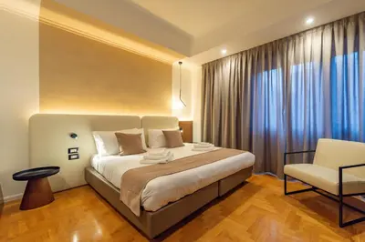 a bedroom with a large bed and a chair at Relais Pamphili guest house by Ghor in Rome