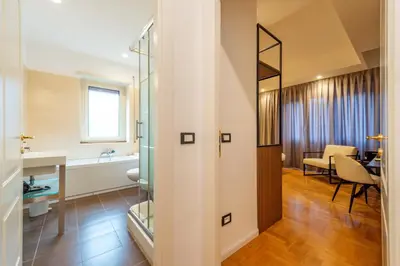 a bathroom with a shower and a sink and a table at Relais Pamphili guest house by Ghor in Rome