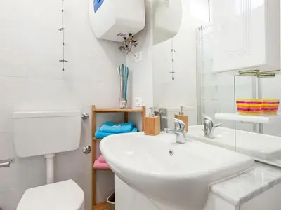 a white bathroom with a sink and a toilet at Condotti Apartment in Rome