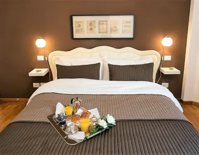 a tray with food and drinks on a bed at Capone Al Vaticano in Rome