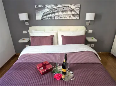 a bed with a bottle of wine and a gift at Capone Al Vaticano in Rome