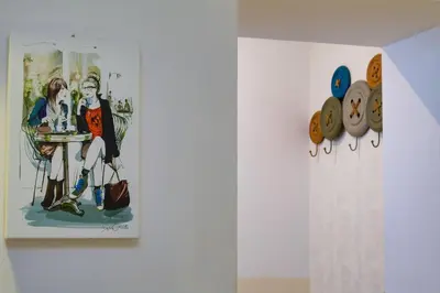 a painting on a wall next to a shelf with shoes at Zefiro Home in Rome