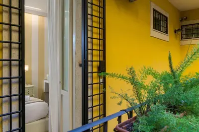 a room with a yellow wall and a balcony at Zefiro Home in Rome