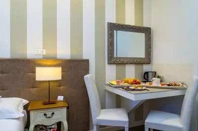 a room with a table with chairs and a mirror at Zefiro Home in Rome