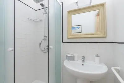 a white bathroom with a sink and a shower at Navona Family Apartment in Rome