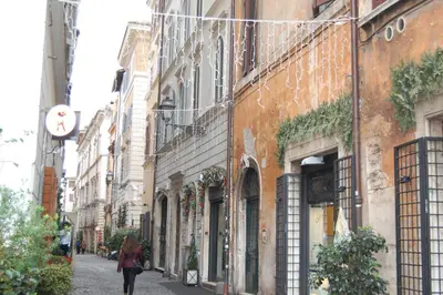 a woman walking down a street next to buildings at Navona Family Apartment in Rome