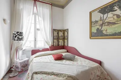 a bedroom with a bed with a red headboard and a window at Navona Family Apartment in Rome