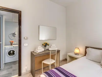 a bedroom with a bed and a desk with a washing machine at Apartment Wohnung mit Wi-Fi by Interhome in Rome