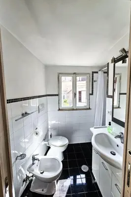 a white bathroom with two toilets and a sink at Apartment Wohnung Monserrato by Interhome in Rome