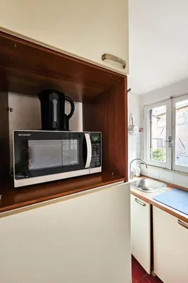 a microwave on top of a refrigerator in a kitchen at Apartment Wohnung Monserrato by Interhome in Rome