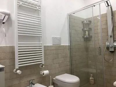a bathroom with a toilet and a glass shower at Apartment GLI ARANCI Wohnung by Interhome in Rome