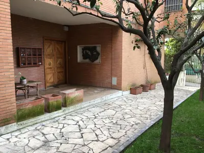 a patio with a table and a wooden door at Apartment GLI ARANCI Wohnung by Interhome in Rome