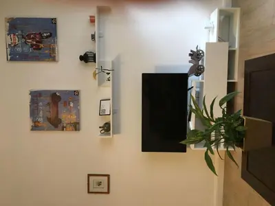 a living room with a tv and some pictures on the wall at Apartment GLI ARANCI Wohnung by Interhome in Rome