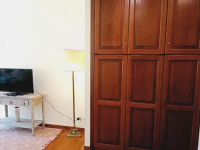 a large wooden cabinet next to a desk with a television at Apartment Rom-Ferienwohnungen - Case Vacanze Roma by Interhome in Rome