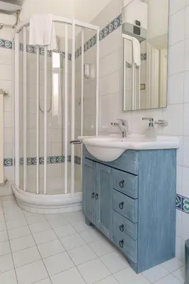 a bathroom with a blue sink and a shower at èROMA - ESQUILINO Apartment in Rome