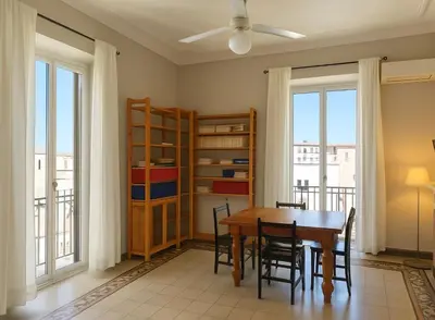 a dining room with a table and chairs and windows at èROMA - ESQUILINO Apartment in Rome
